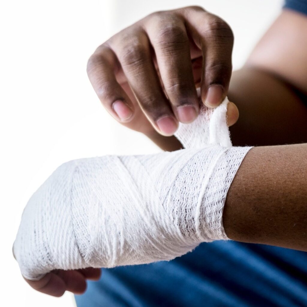 injured person wrapping their hand with bandage