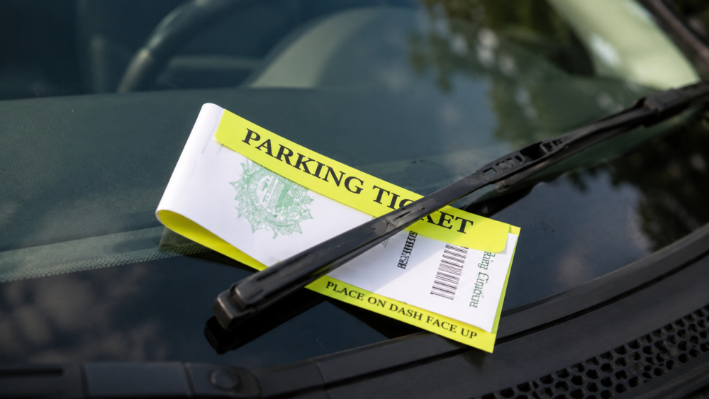 yellow parking ticket on car windshield